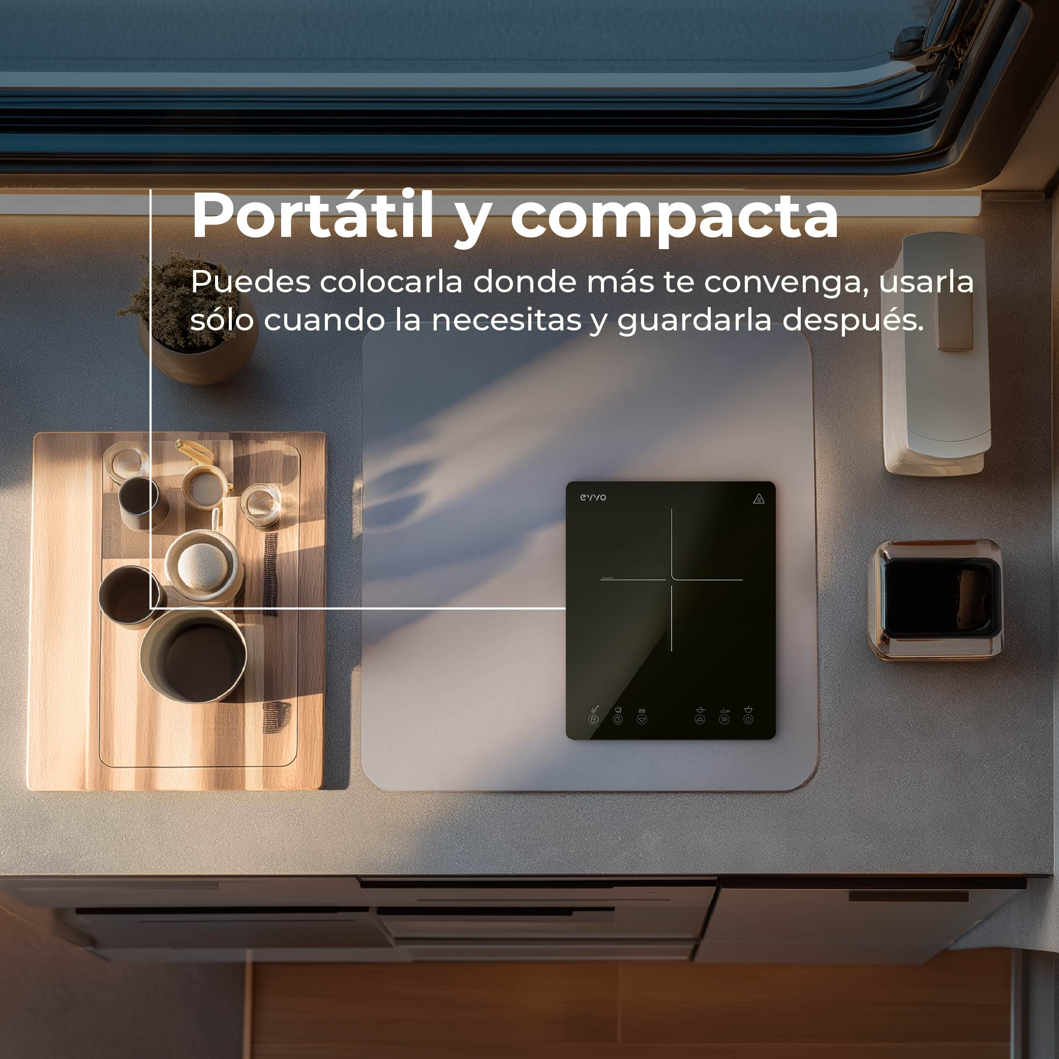 Un piano cottura a induzione portatile su un piano di lavoro con tazze e vassoio.