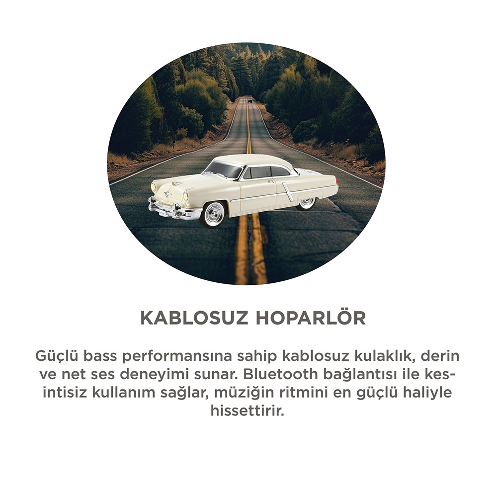 Krem rengi klasik bir araba ormanlık bir yolda ilerliyor.