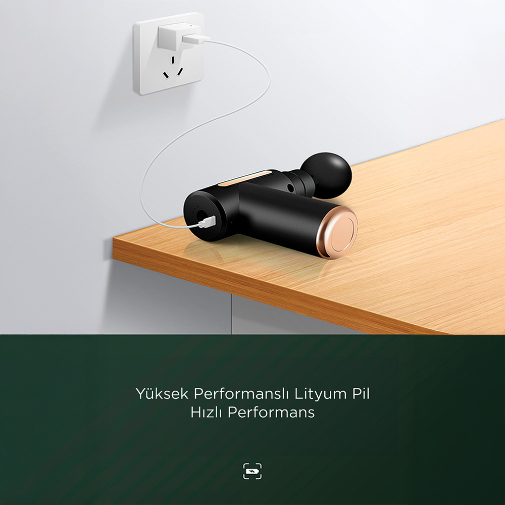 Siyah masaj tabancası duvardaki prize USB ile şarj oluyor.