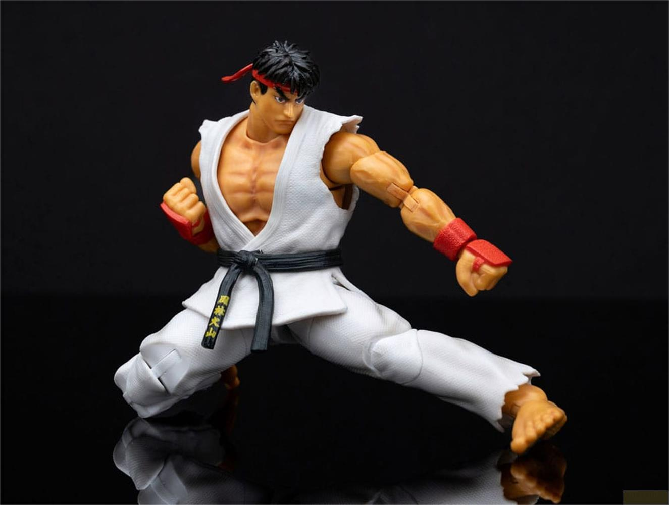 Action figure di un uomo in un gi da karate bianco, fascia rossa e polsini rossi.
