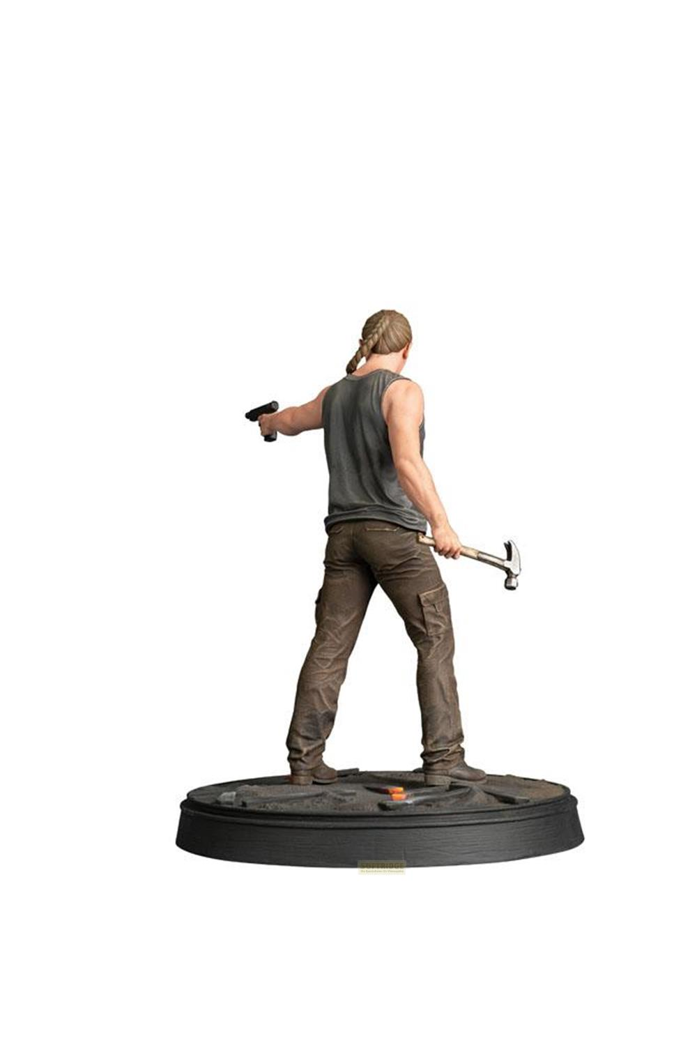 Una figura con pistola y martillo, de pie sobre una base.