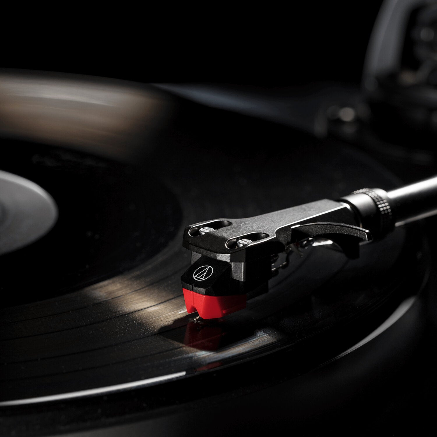 Le stylet d'un tourne-disque à pointe rouge sur un disque vinyle noir.