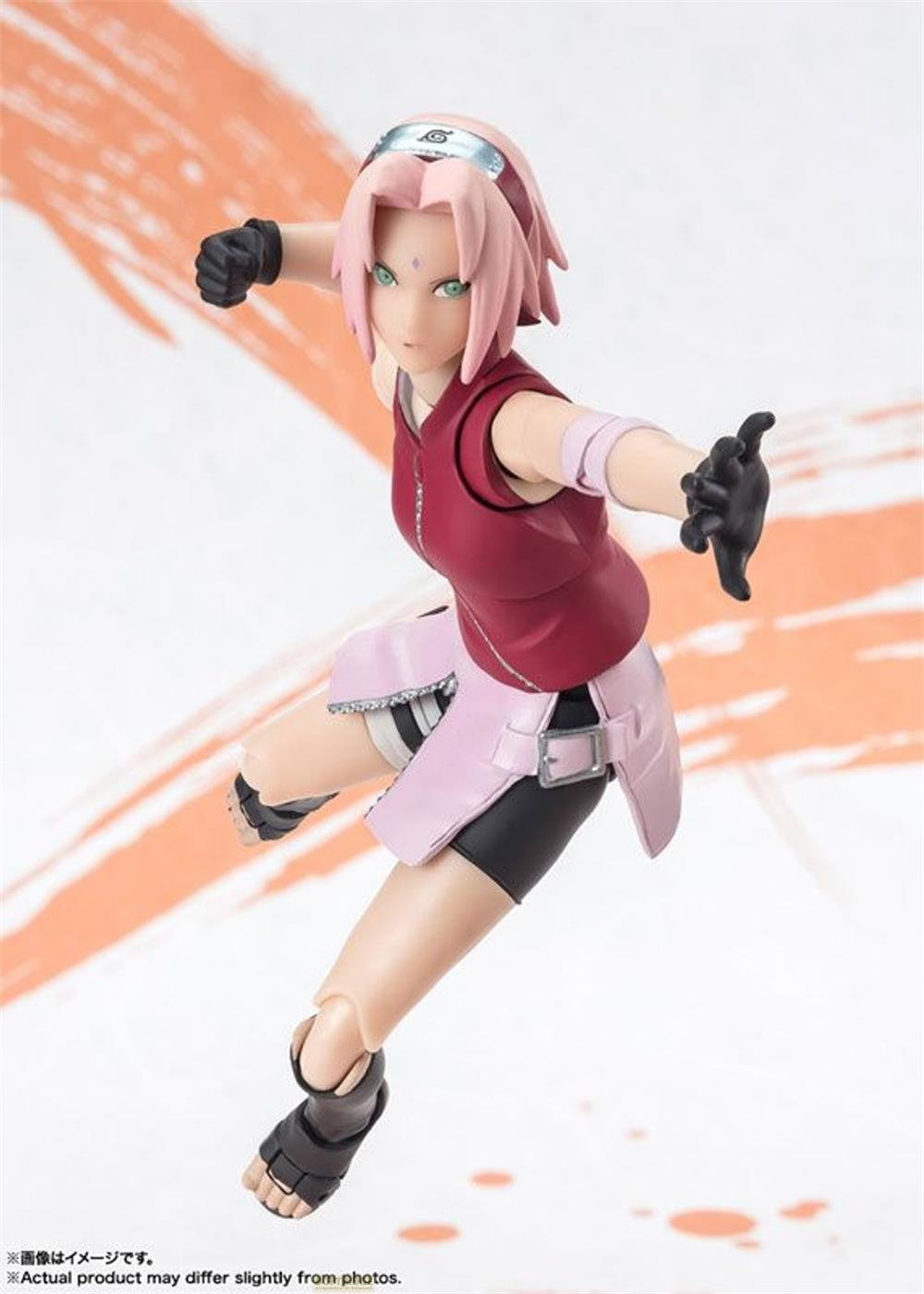 Figura de Sakura en pose de combate, con top rojo y falda rosa.