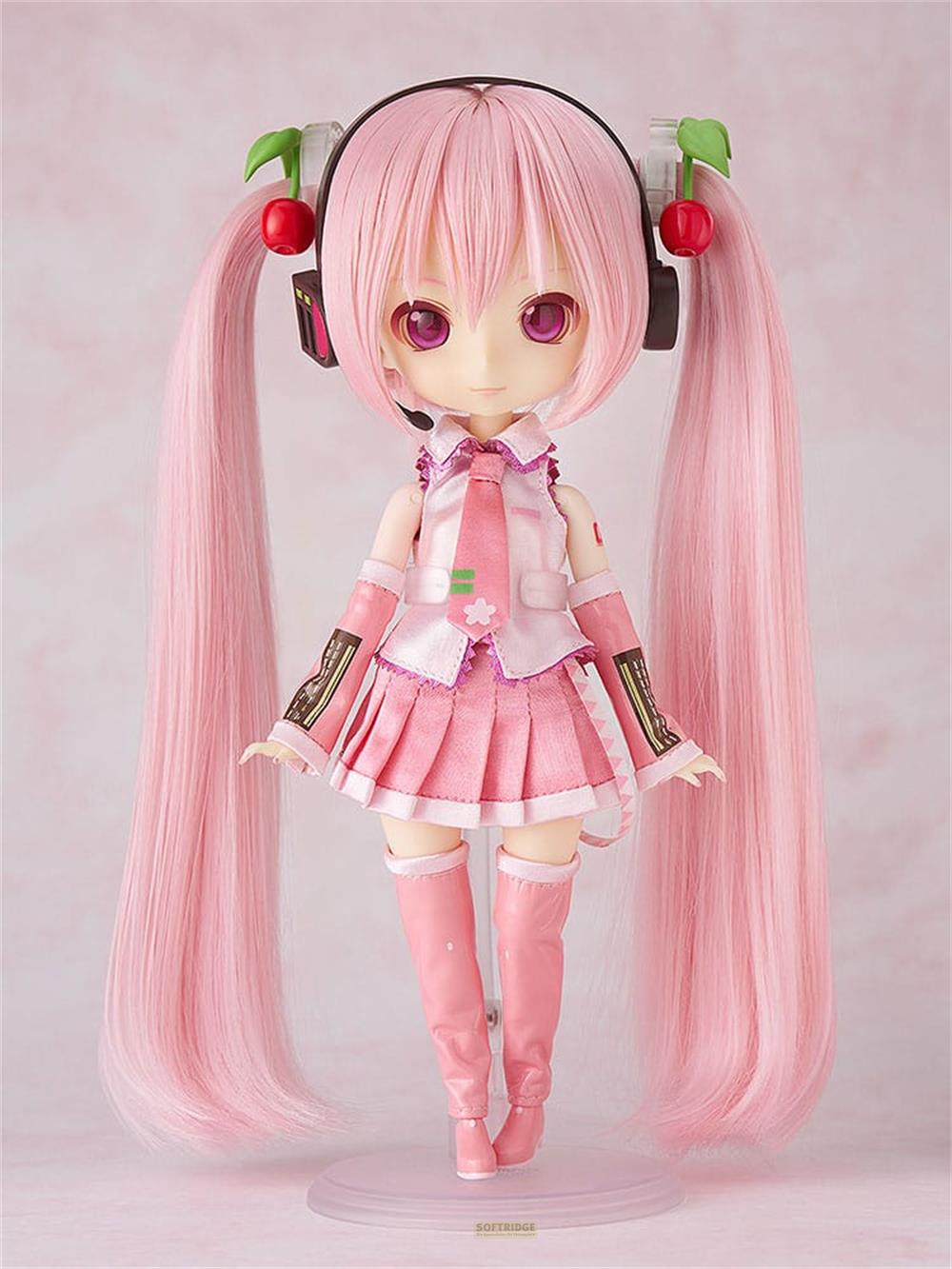 Una bambola con lunghi capelli rosa, occhi viola, cuffie e ciliegie.