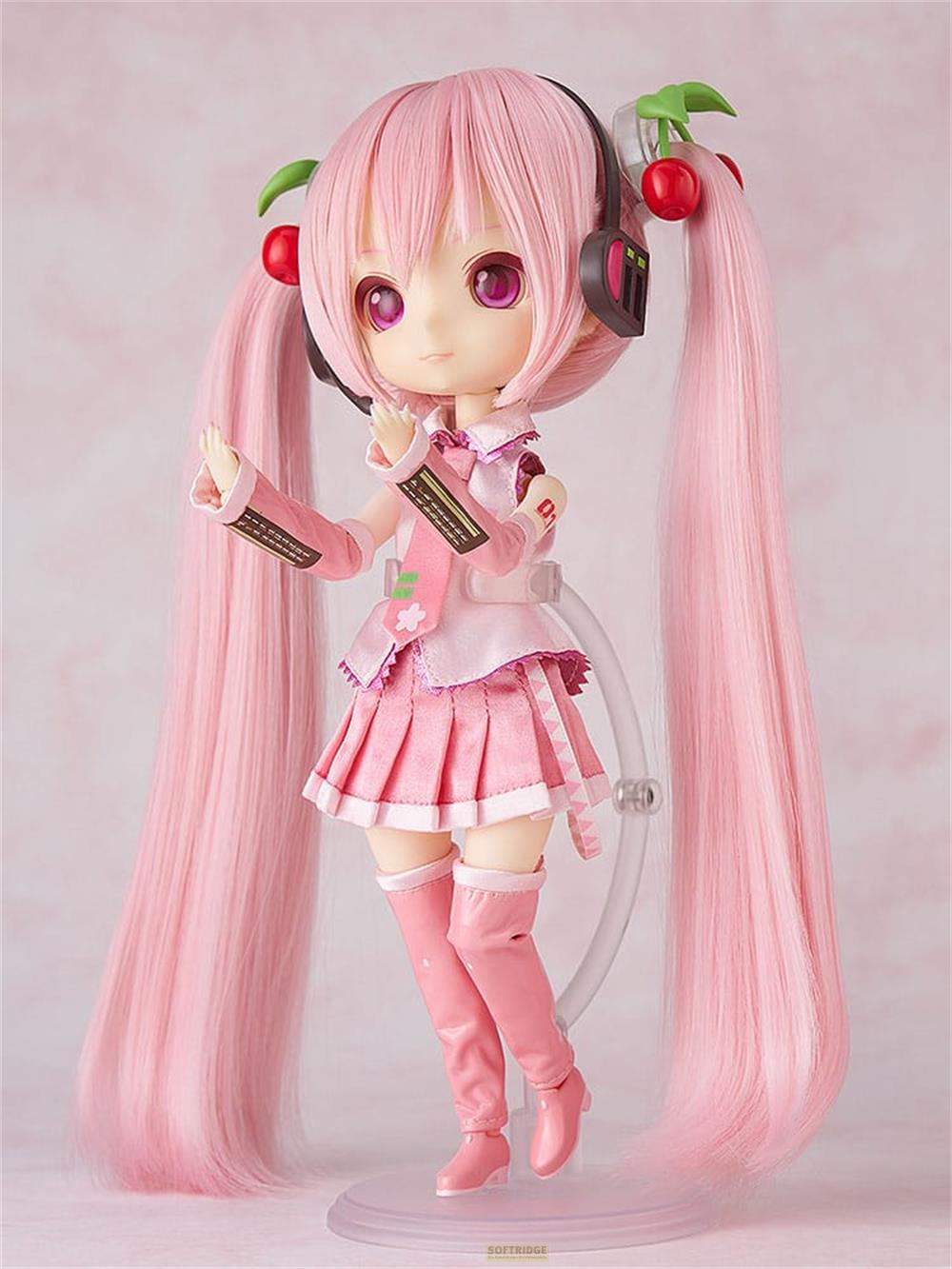 Una bambola con capelli rosa e code, indossa cuffie rosa, un outfit rosa e stivali.