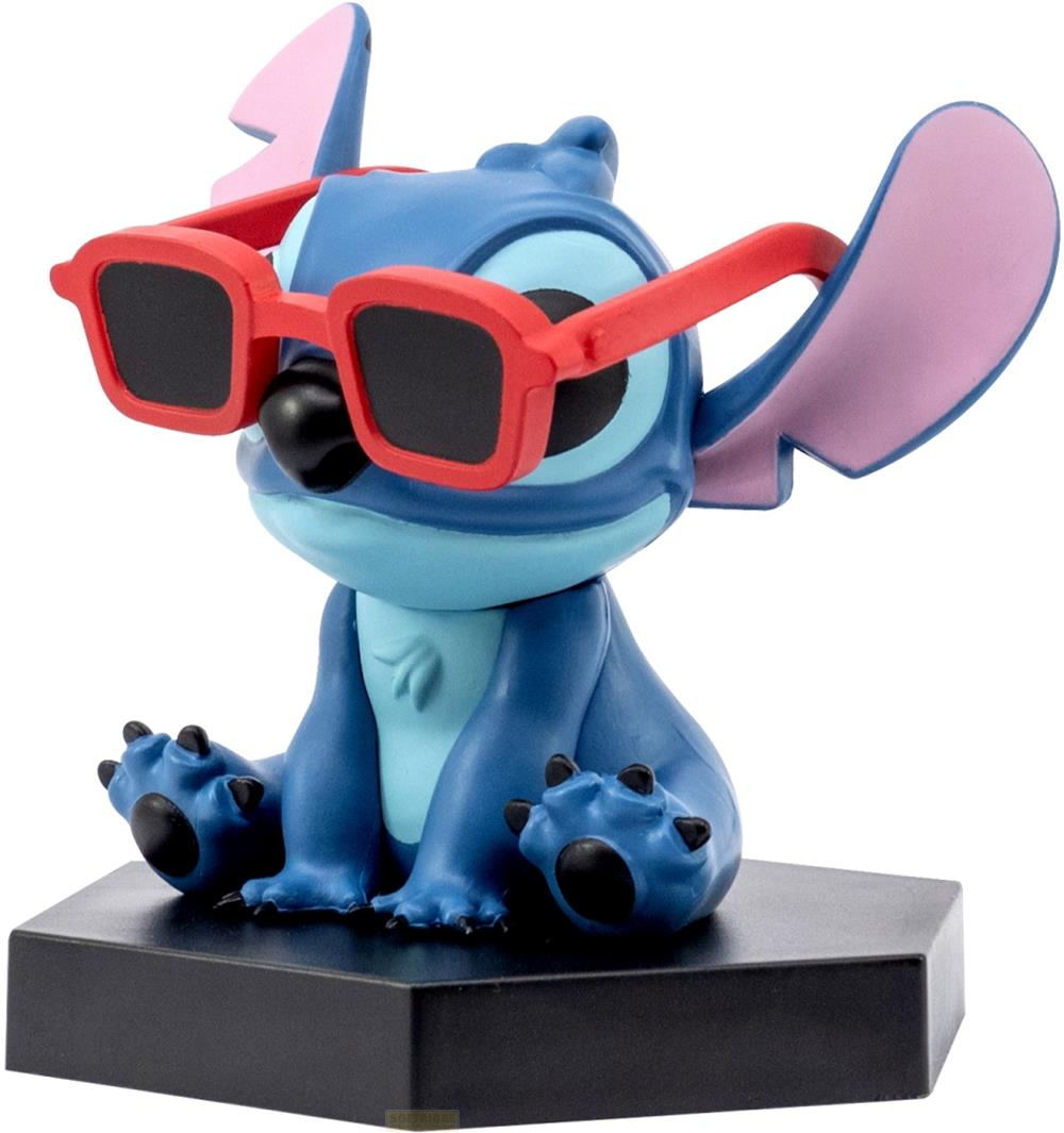 Eine blaue Figur mit roten Brillen sitzt auf einem schwarzen Sockel.
