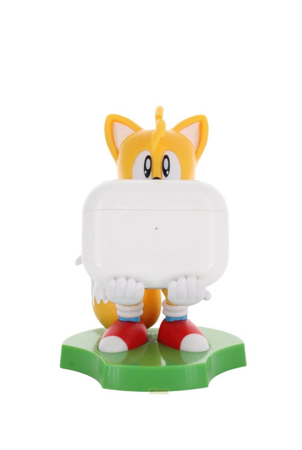 Una figura di Tails di Sonic tiene una custodia bianca davanti a sé su una base verde.