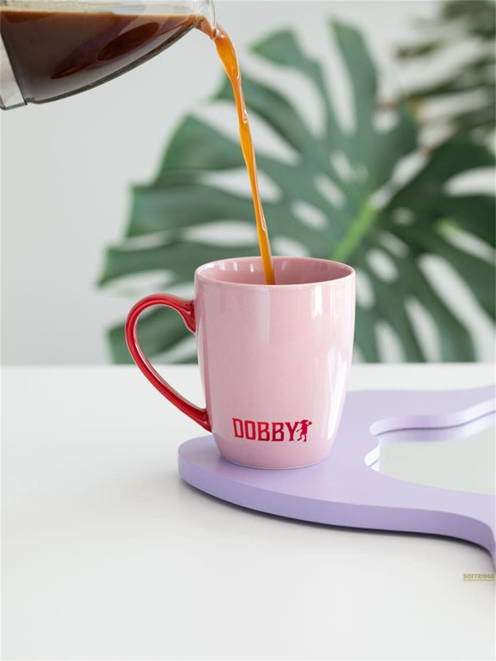 El café se vierte en una taza rosa con asa roja.