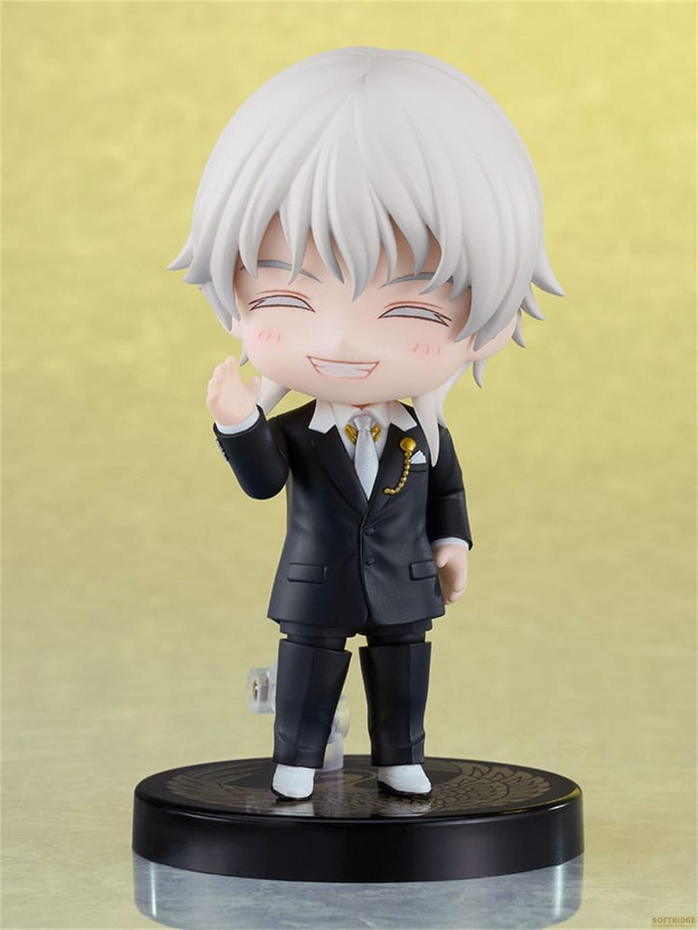Una figura anime con capelli bianchi in abito nero saluta.
