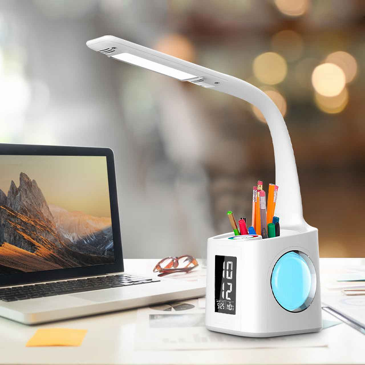 Ein weier Schreibtisch mit einem Laptop, einer Lampe und Stiften.