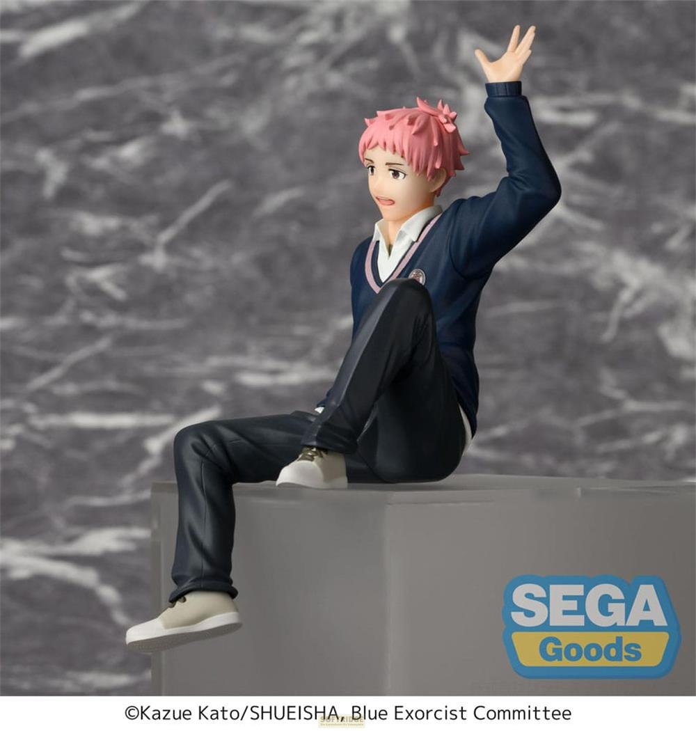 Une figurine aux cheveux roses porte un pull bleu foncé et un pantalon noir.