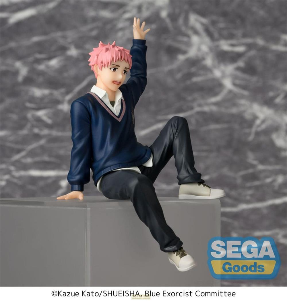 Une figurine aux cheveux roses, portant un pull bleu et un pantalon foncé, est assise sur un rebord.