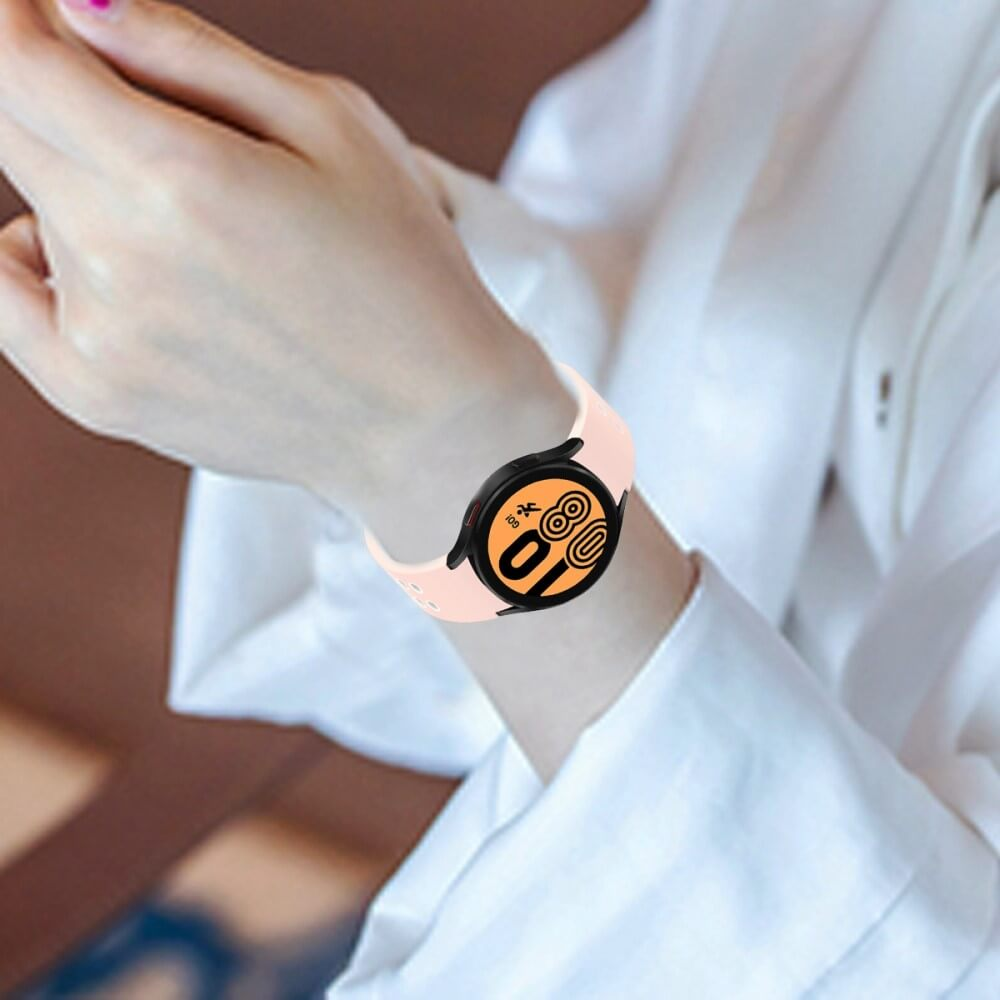 Una persona indossa un cinturino rosa chiaro per smartwatch sul polso sinistro.