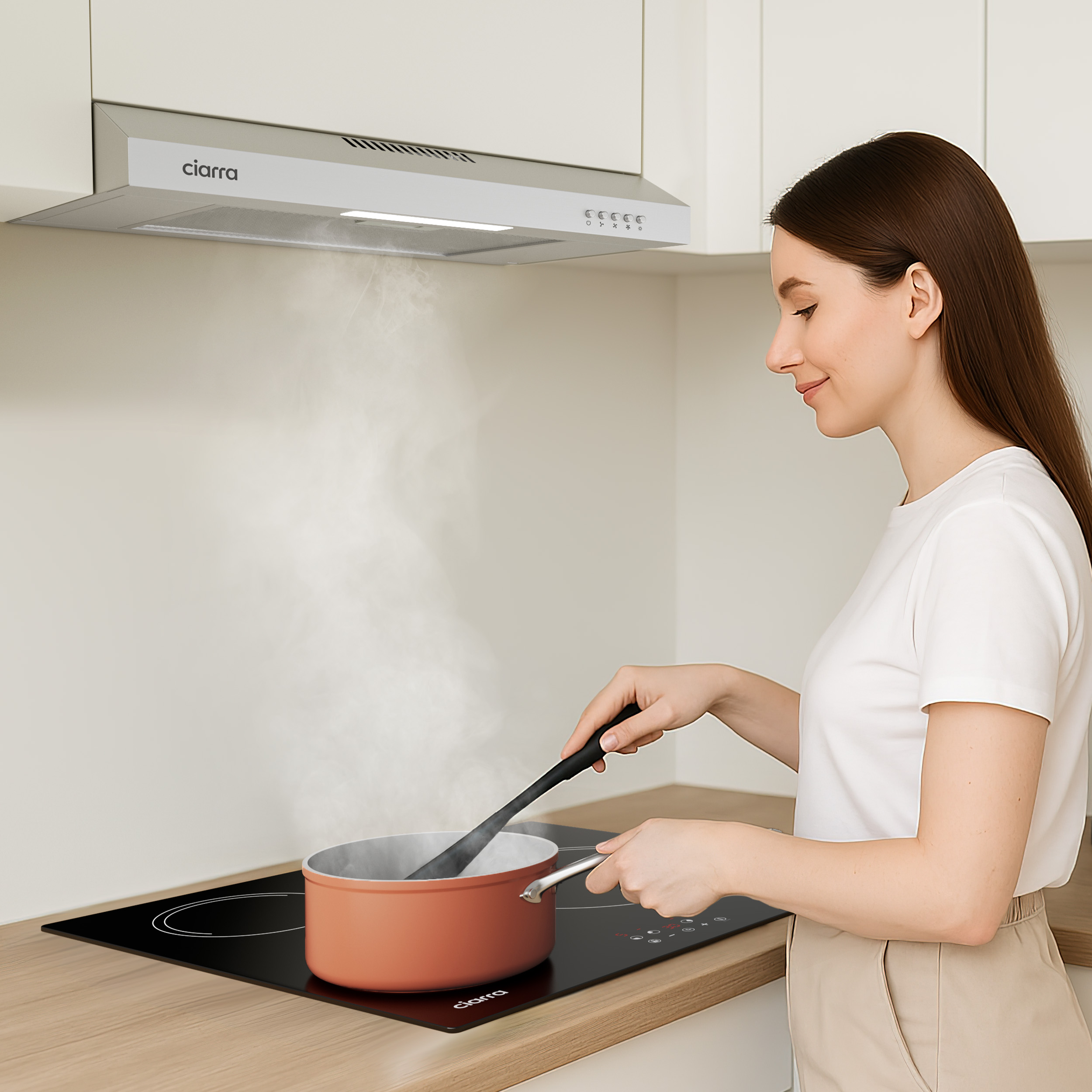 A woman cooks on an induction hob with a pot, steam rising.