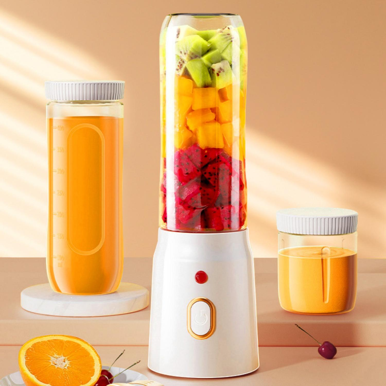 Ein Mixer mit Fruchtstücken und zwei Gläsern Saft.