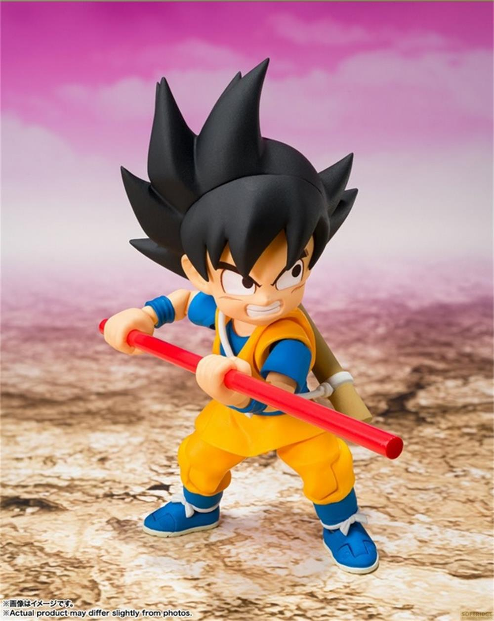 Una figura del niño Goku sostiene un bastón rojo. Viste un gi naranja y camiseta azul.