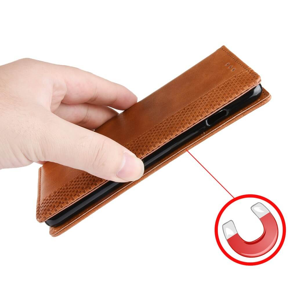 Étui de téléphone en cuir marron tenu à la main, fermeture magnétique.