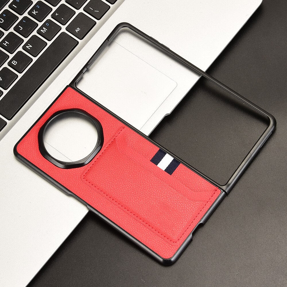 Coque de téléphone rouge à rayures à côté du clavier d'un ordinateur portable.