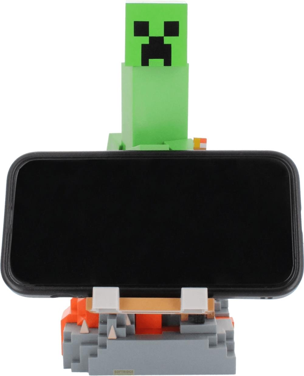 Un Creeper Minecraft verde tiene uno smartphone su un supporto pixelato.