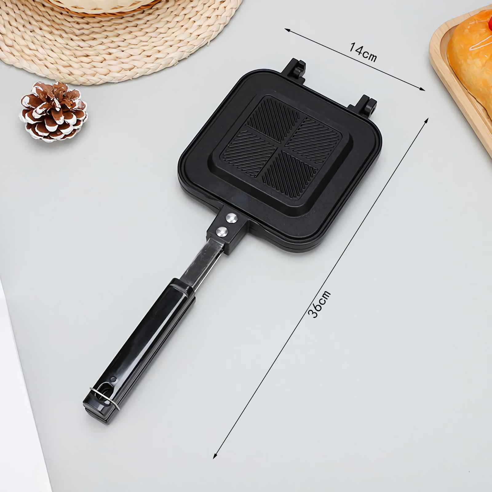 Schwarzer Sandwichmaker mit Griff, 36cm lang, 14cm breit.