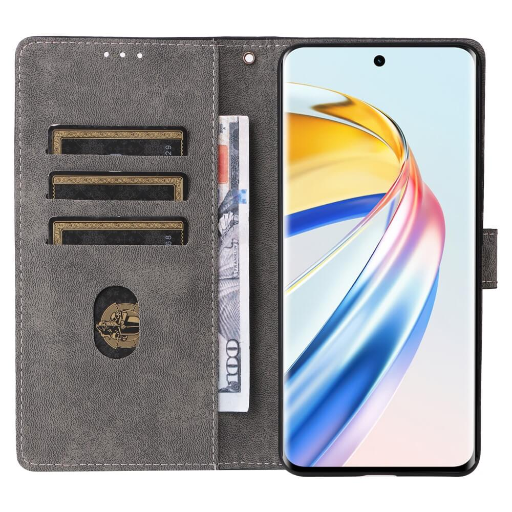 Étui de téléphone gris avec fentes pour cartes et un billet, à côté d'un smartphone.