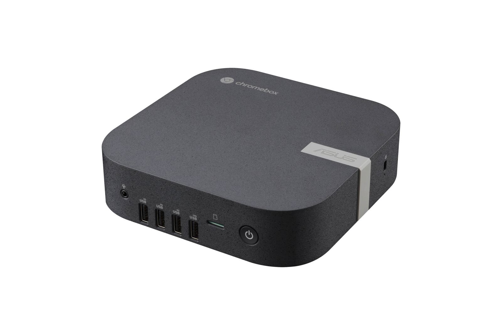 Un ASUS Chromebox gris oscuro sobre fondo blanco. Tiene puertos USB y un botón de encendido.