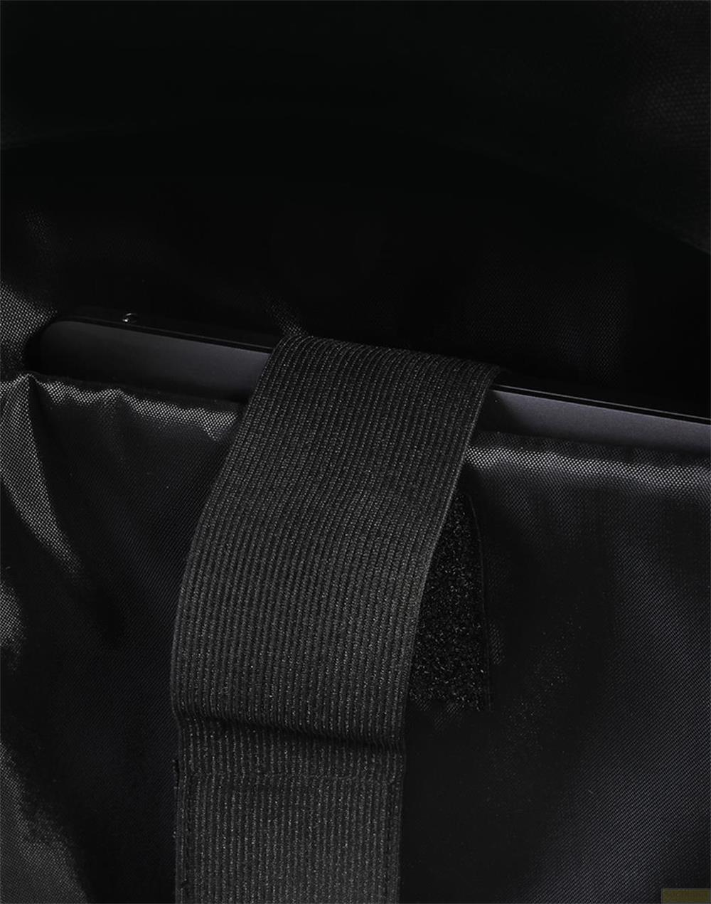 Schwarzer Riemen mit Klettverschluss auf schwarzem Stoff.