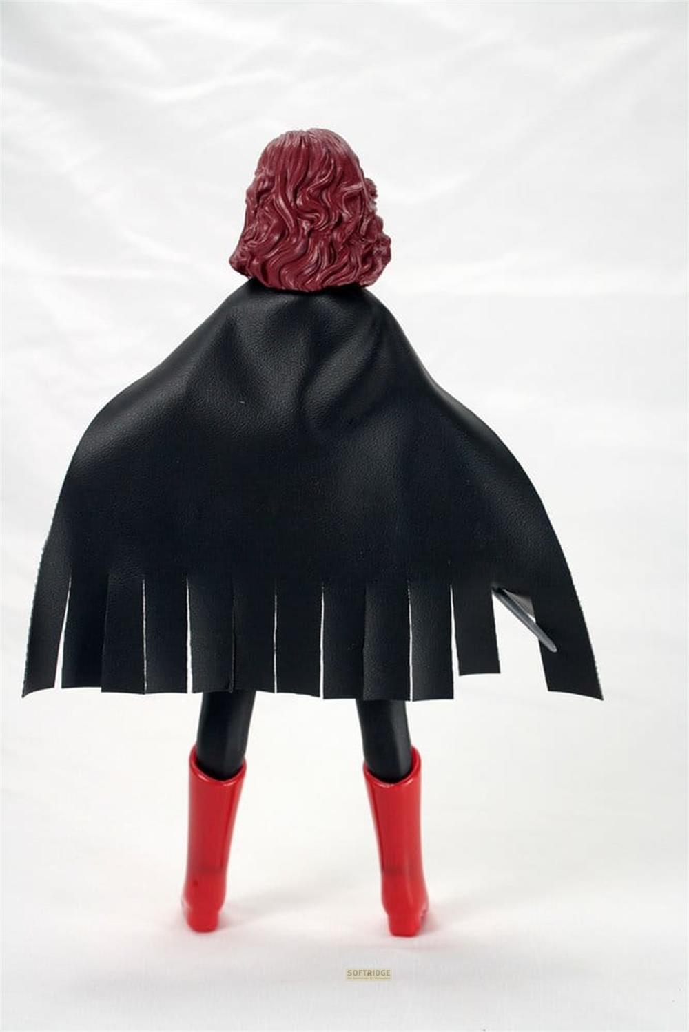 Rückansicht einer Actionfigur mit rotem gewelltem Haar, schwarzem Umhang und roten Stiefeln.