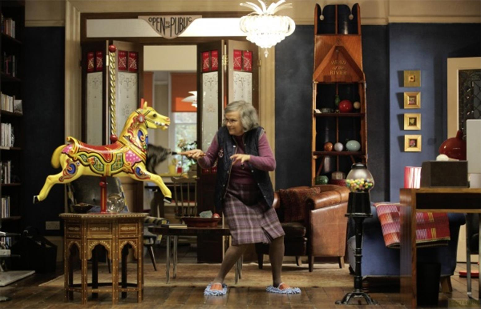 Una donna accanto a un cavallino da giostra colorato con giocattoli.