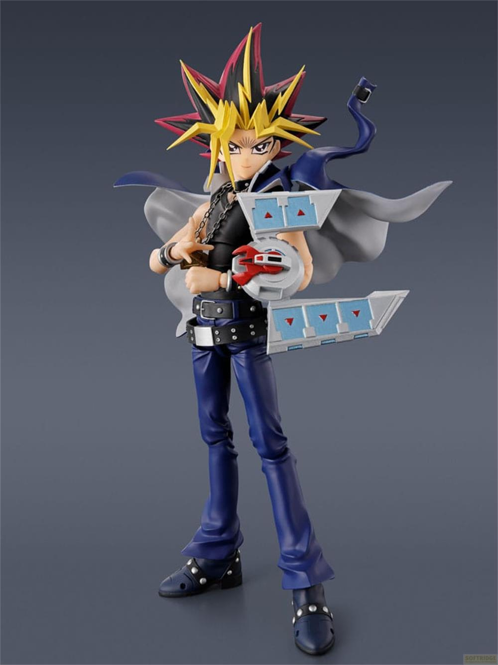 Eine Figur von Yami Yugi mit seinem Duell-Disk und einer Kapuze.