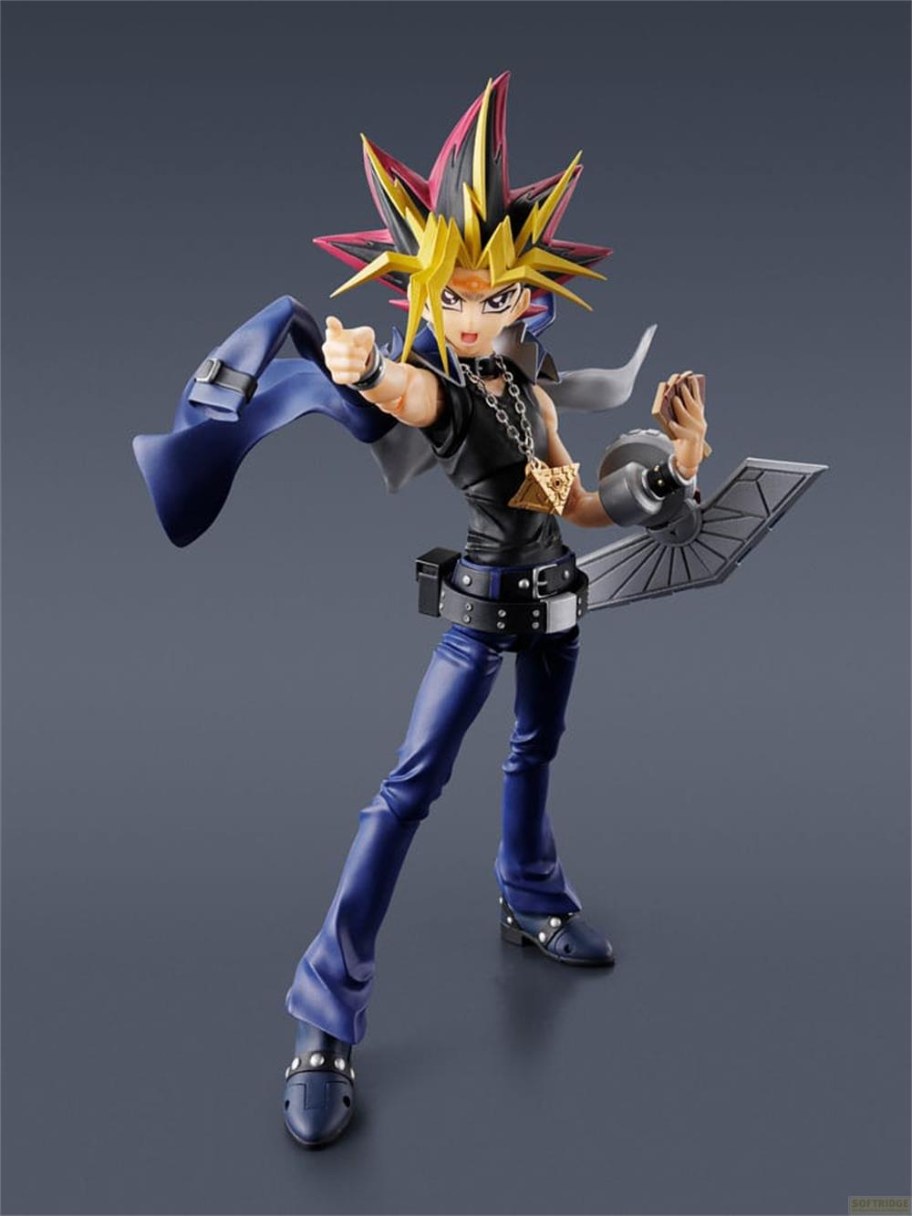 Eine Figur von Yami Yugi mit zerzaustem Haar, schwarzer Kleidung und blauen Hosen.