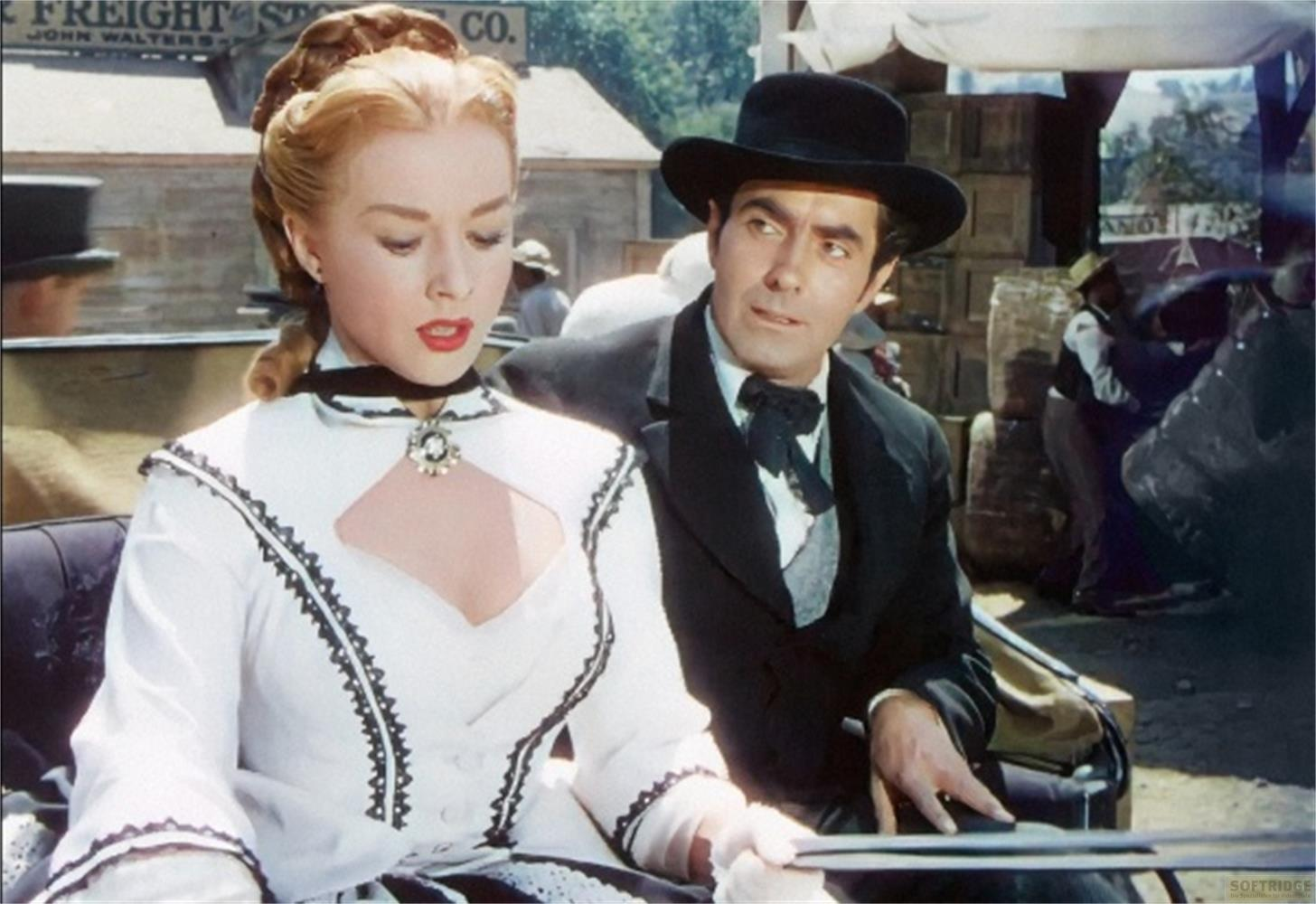 Una donna in abito bianco e un uomo in abito nero siedono in una carrozza.