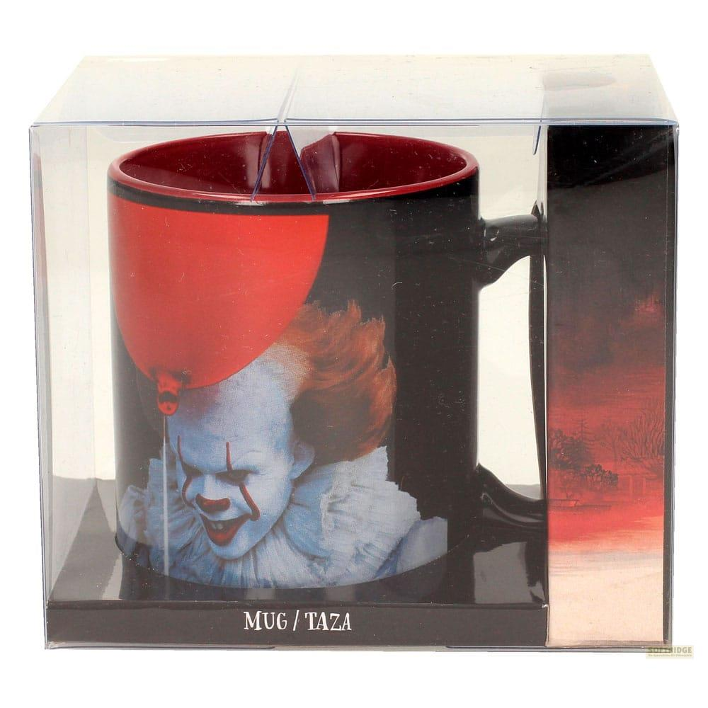 Taza negra con cara de Pennywise y globo rojo en embalaje.