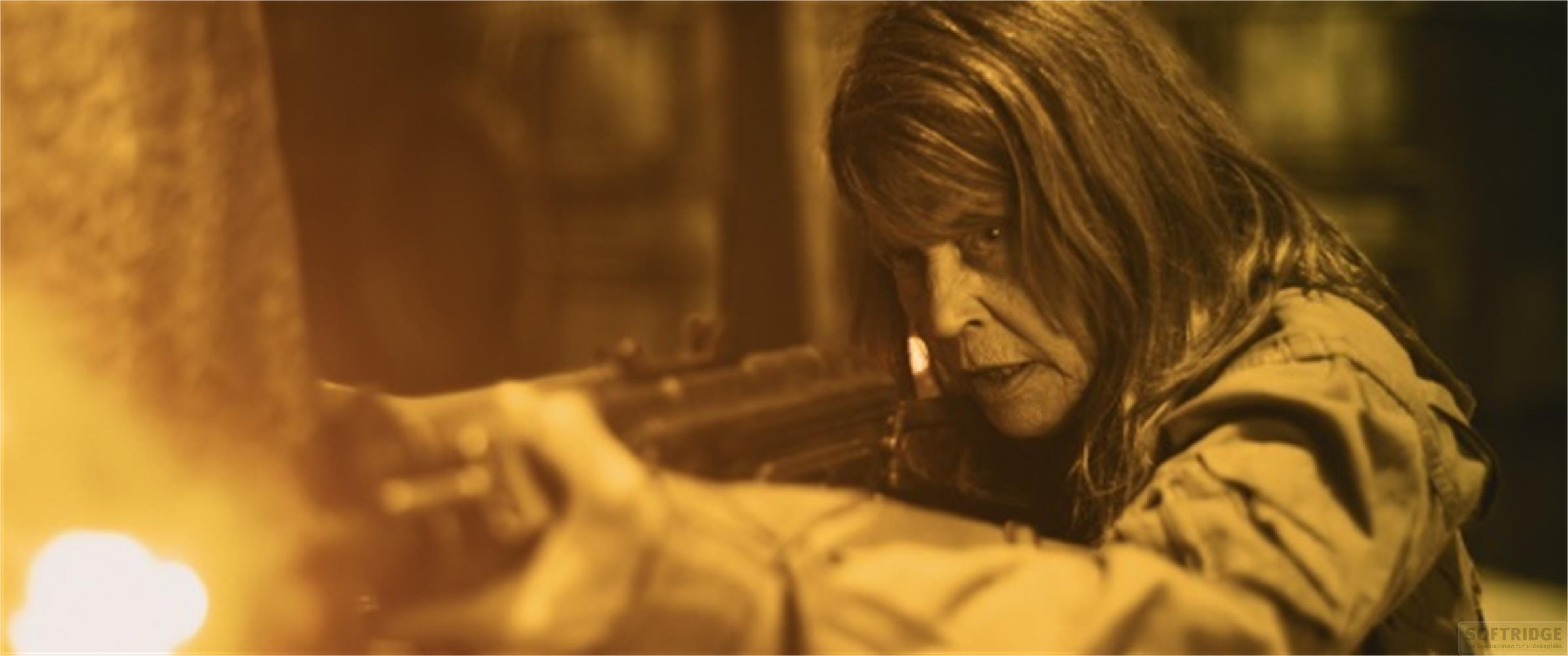 Eine Frau mit langen Haaren zielt mit einem Gewehr, ihr Gesicht ist angespannt.