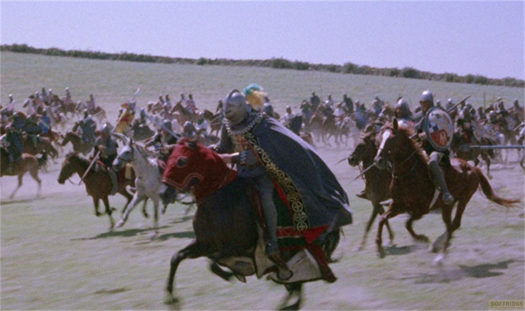 Cavalieri a cavallo caricano attraverso un campo sotto un cielo sereno.