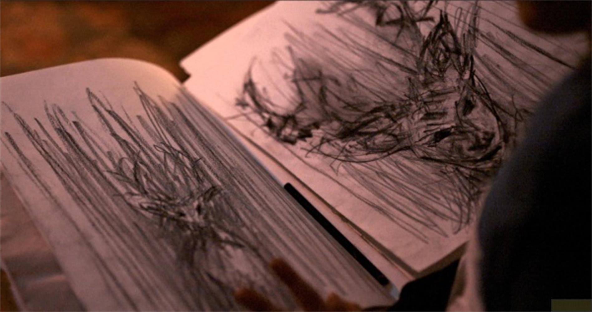 Un taccuino aperto con disegni a matita di piante e una testa.