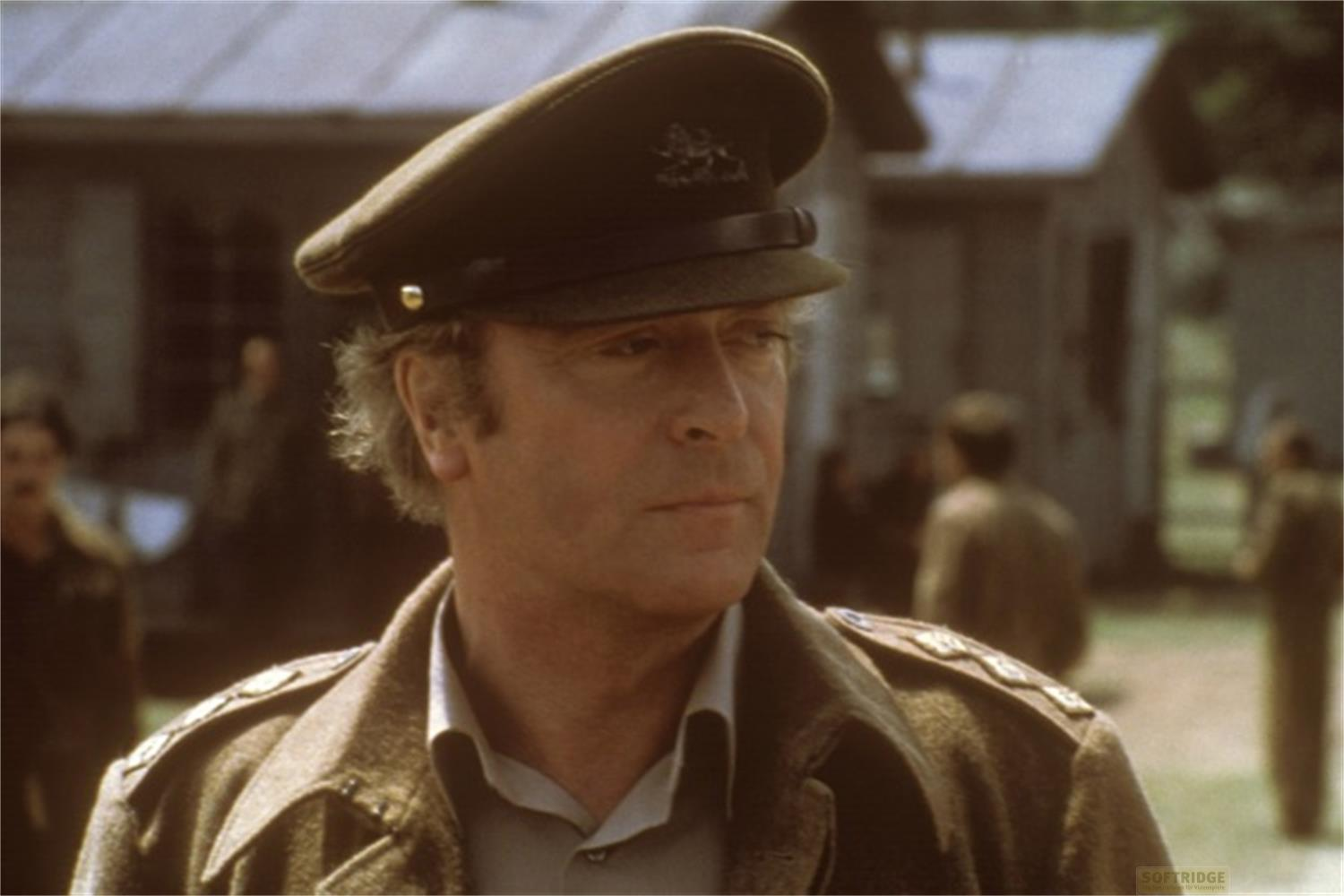 Ein Mann in Uniform mit Hut und Jacke blickt nach rechts.