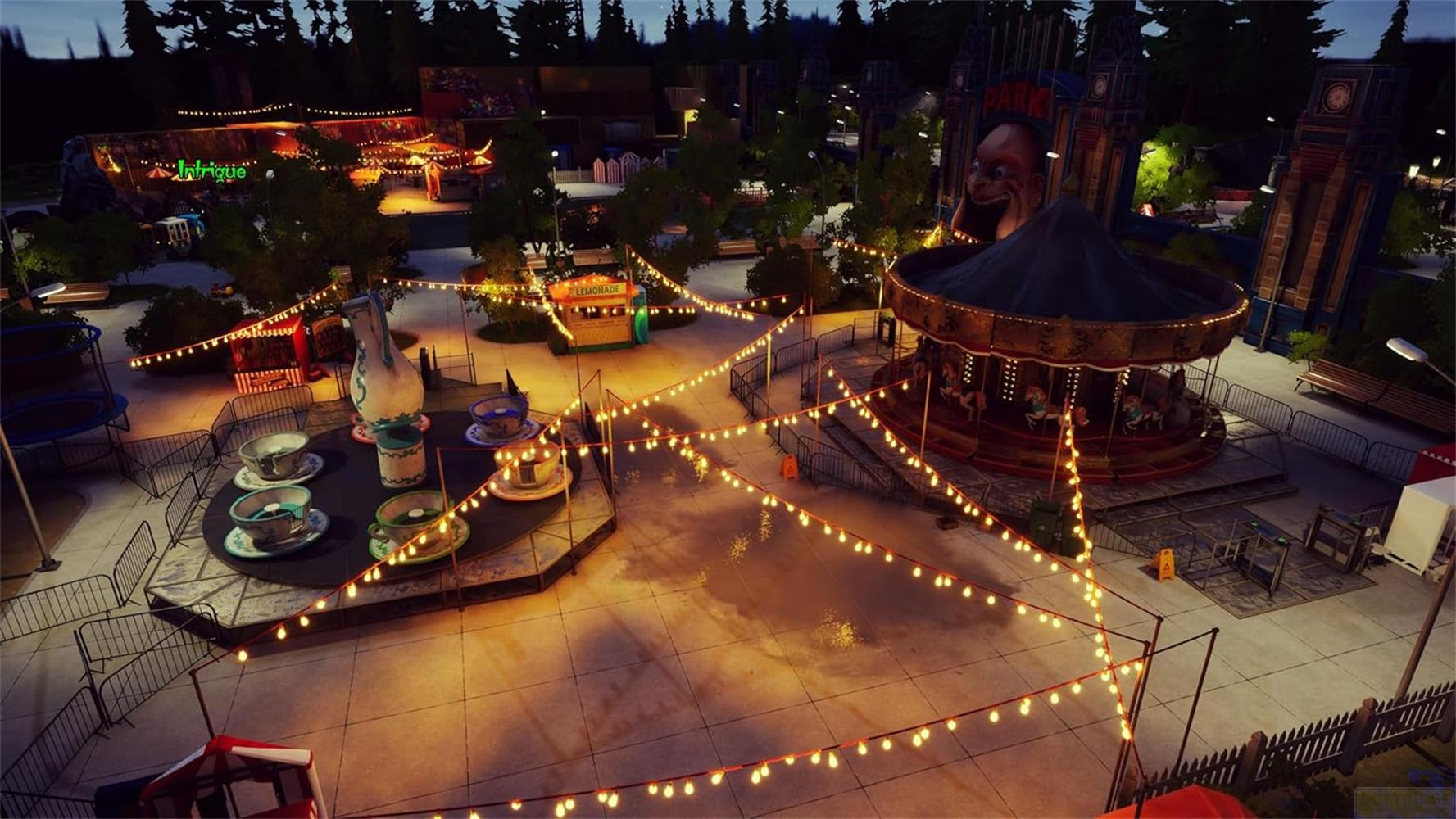 Parc d'attractions de nuit avec carrousel, tasses et guirlandes lumineuses.