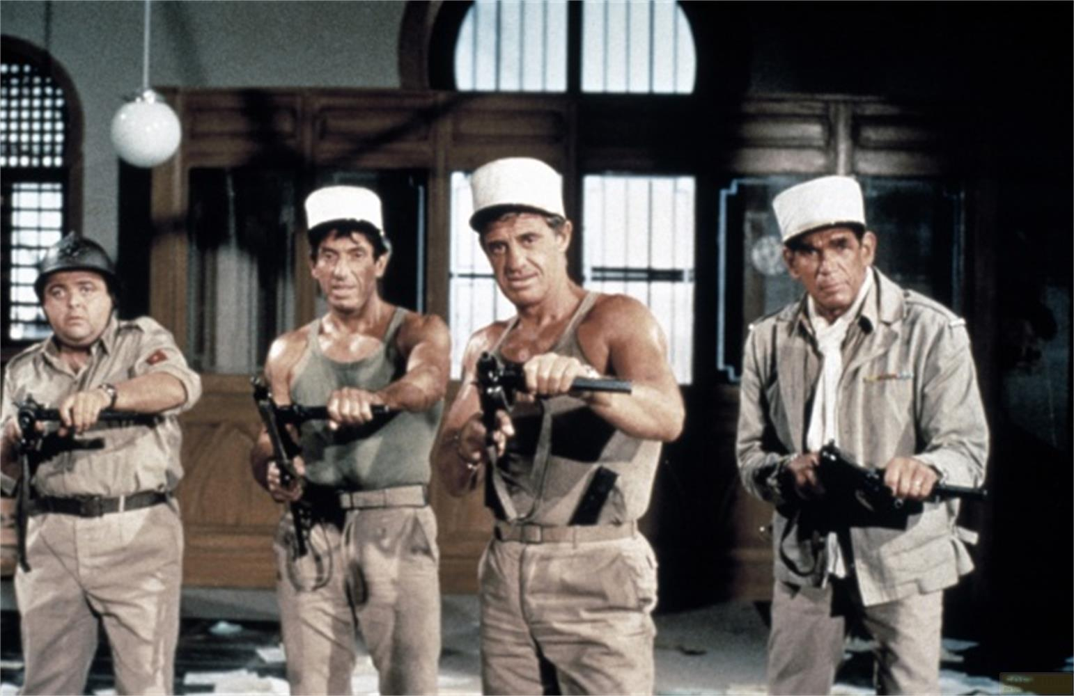 Quattro uomini in uniforme e cappelli bianchi tengono armi.
