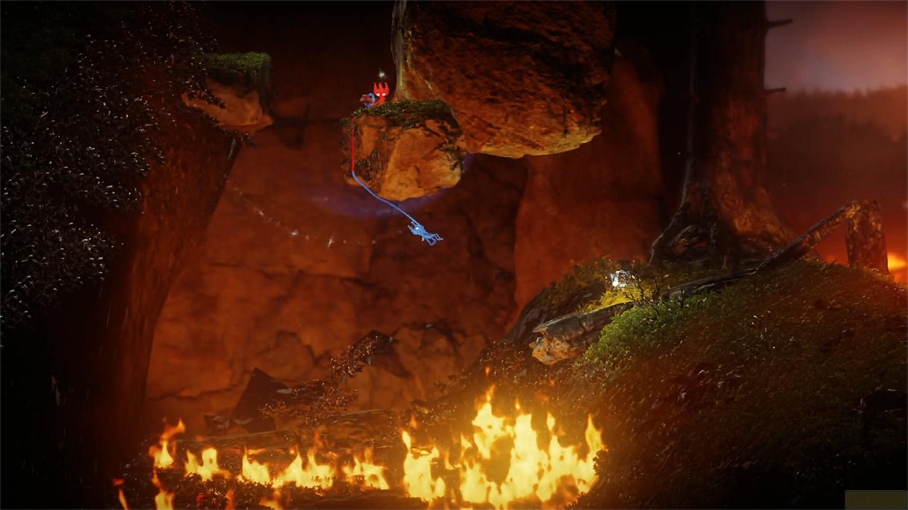 Un personnage bleu se balance sur une corde sous un rocher, avec des flammes en dessous.