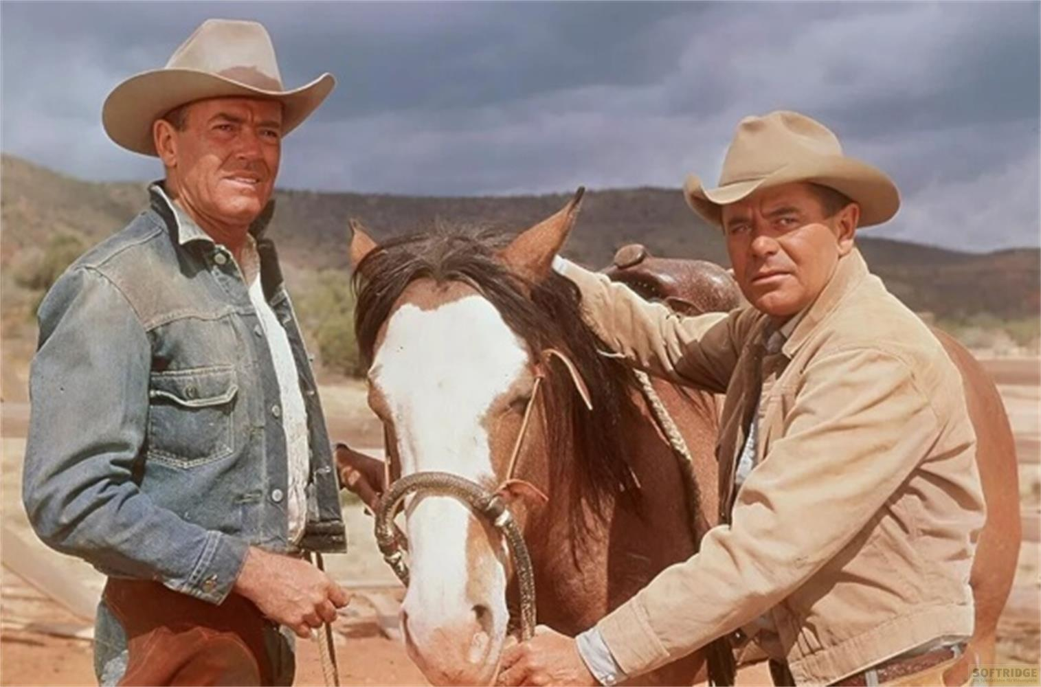 Due cowboy accanto a un cavallo marrone con balza bianca.