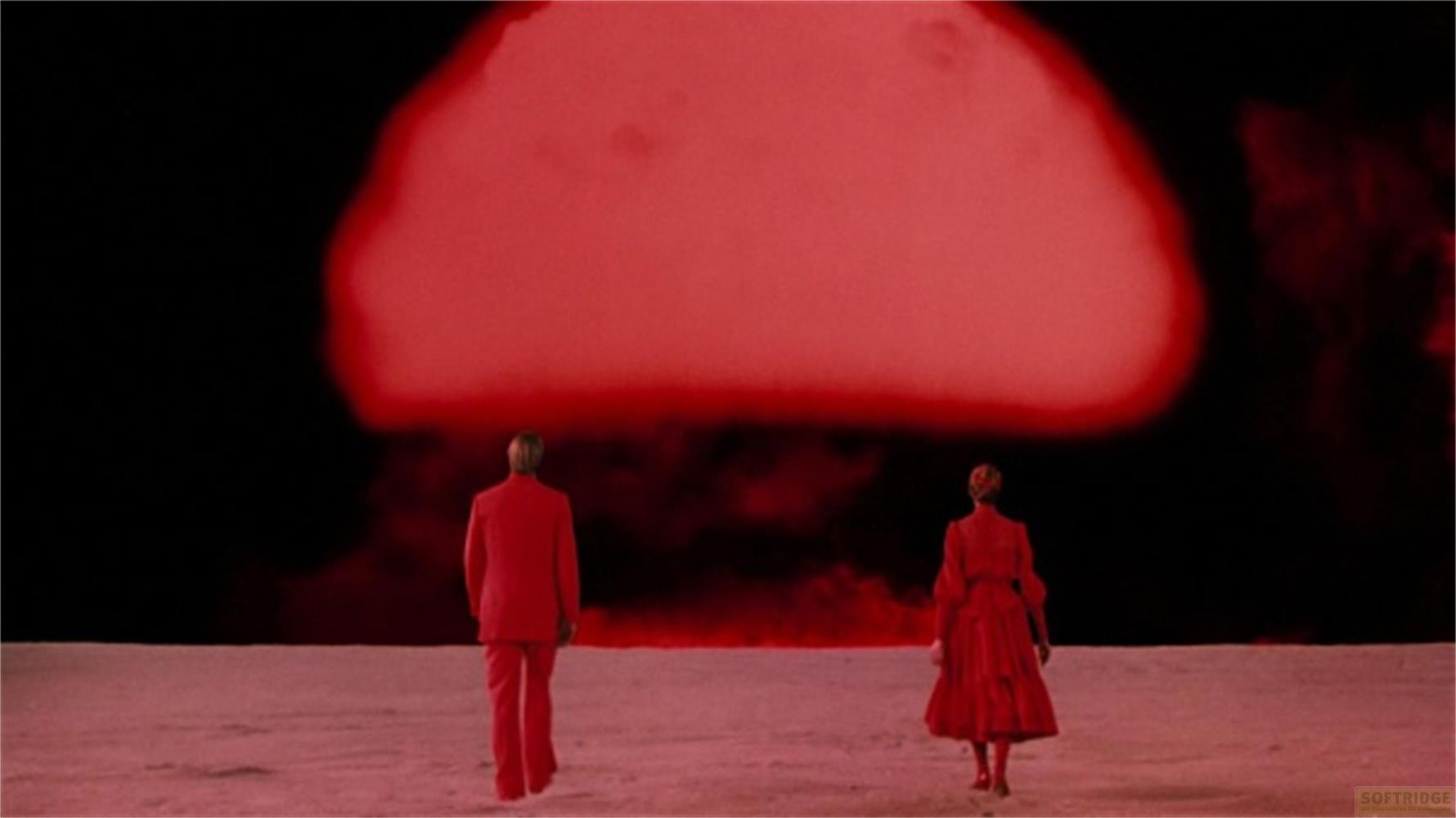 Un uomo e una donna in rosso di fronte a una gigantesca esplosione rossa.
