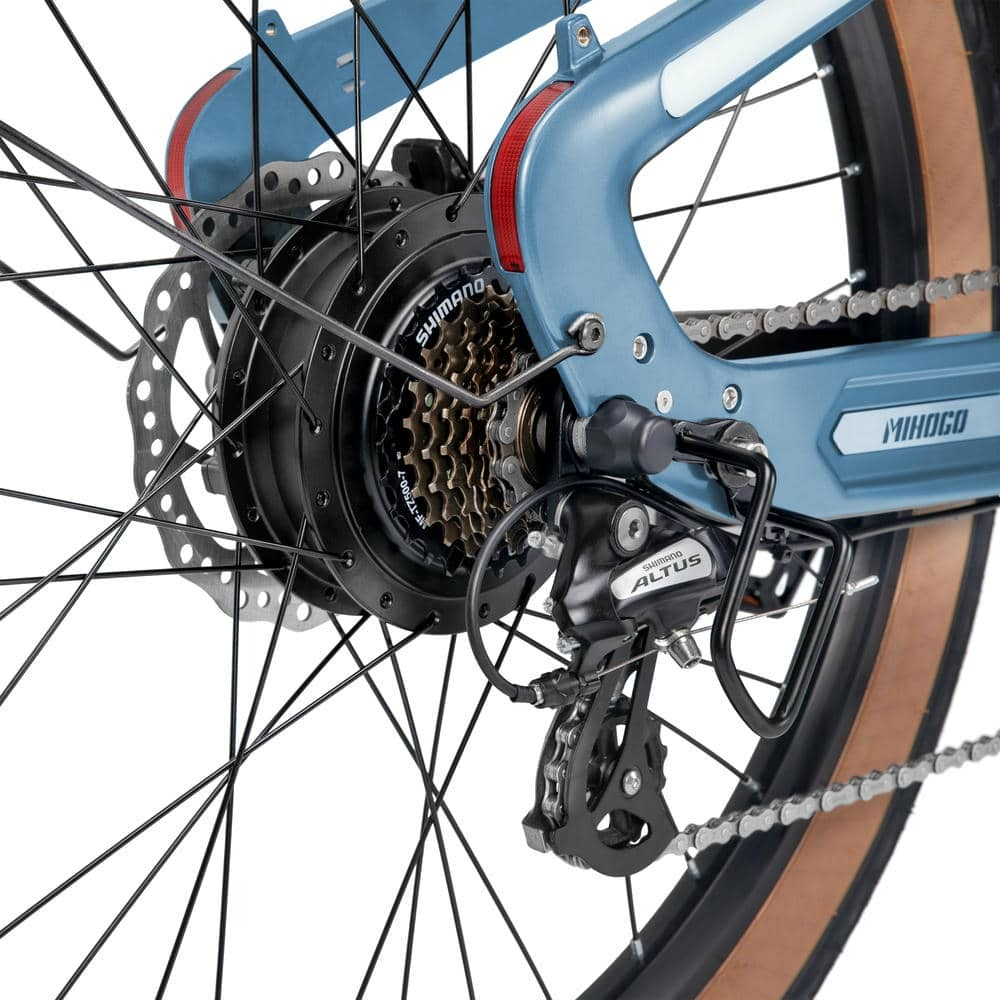 Zbliżenie tylnego koła niebieskiego roweru, pokazujące biegi i łańcuch.