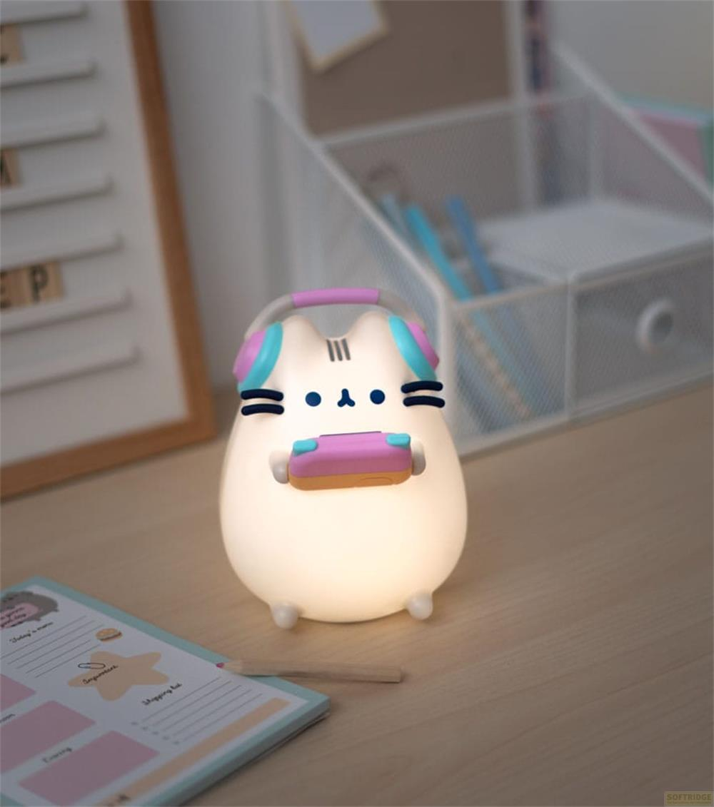 Eine weiße Kawaii-Katzenlampe mit Kopfhörern und Controller auf einem Schreibtisch.