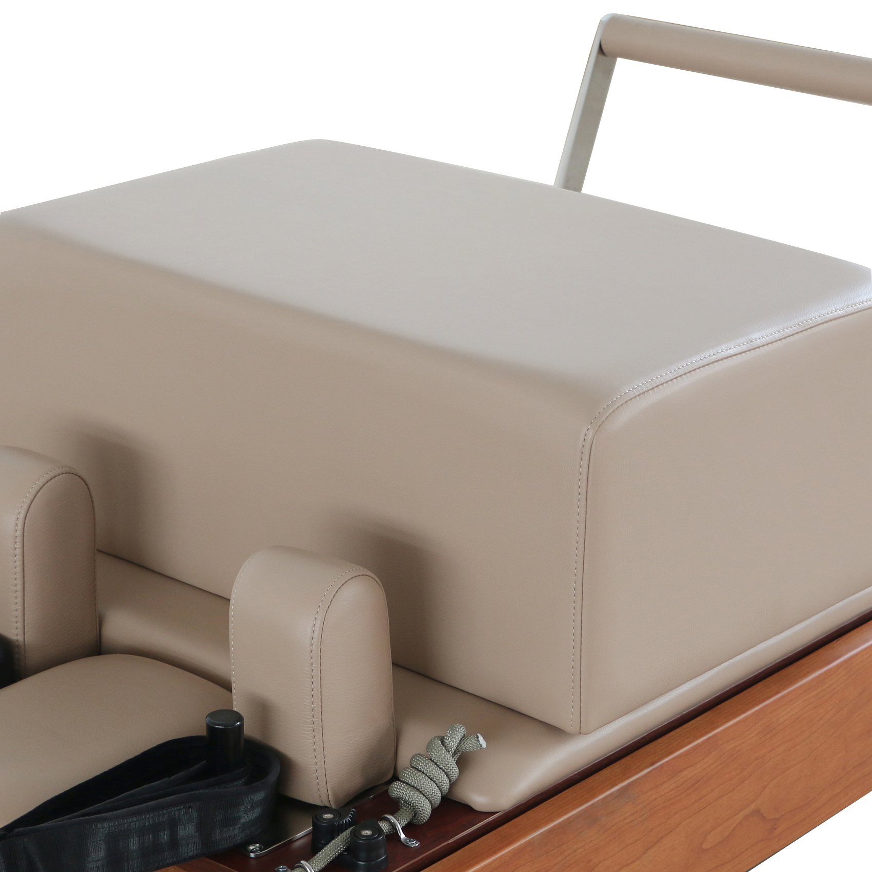 Un reformer Pilates beige con imbottitura in pelle e accenti in legno.