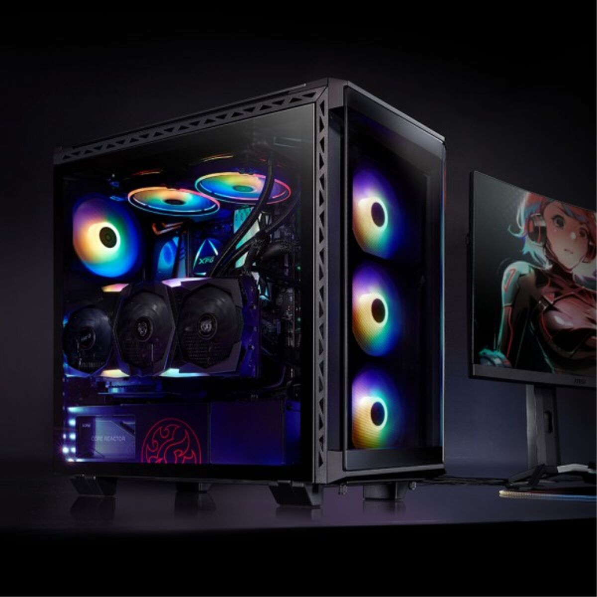 Un tower PC illuminato con ventole colorate e un monitor con figura anime.