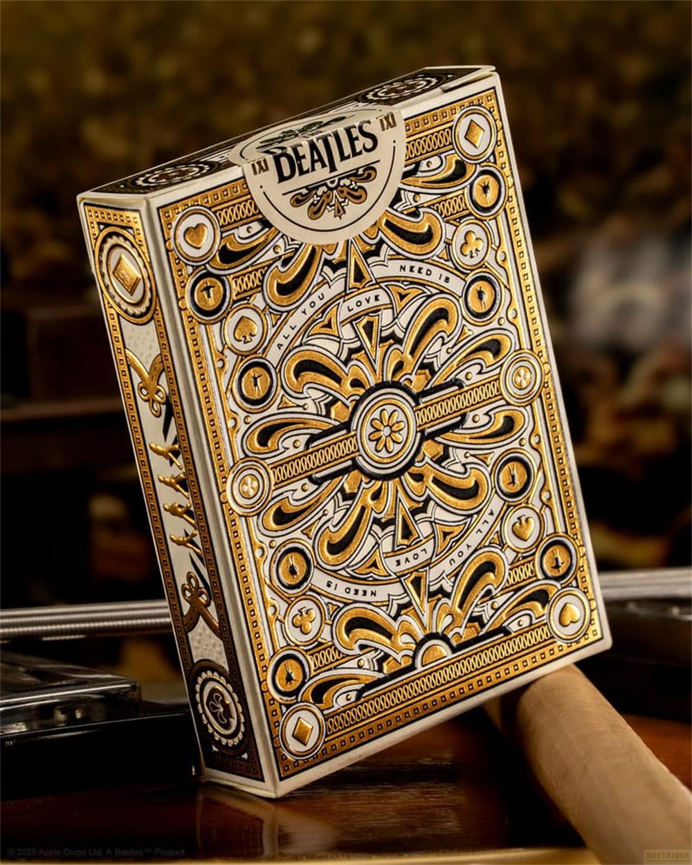 Una scatola di carte da gioco bianca e dorata dei Beatles con motivi intricati.