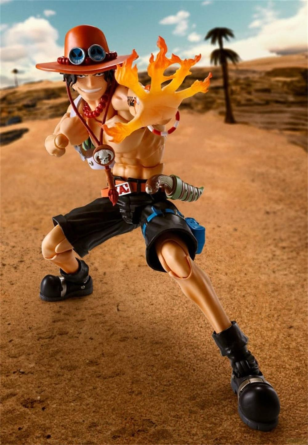 Una action figure di un uomo con cappello e fiamme sulla mano sta nella sabbia.
