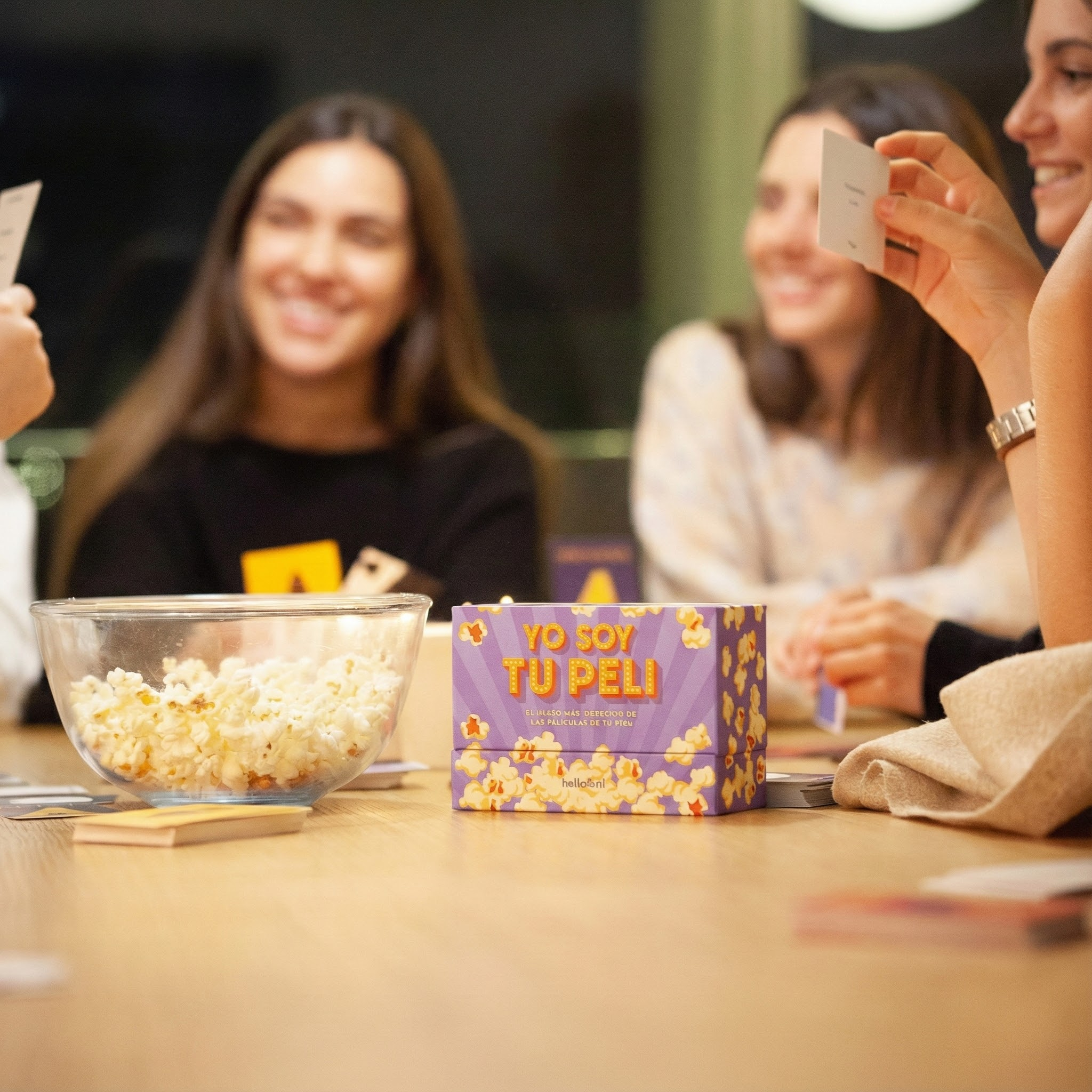 Cuatro mujeres juegan a un juego con palomitas en la mesa.