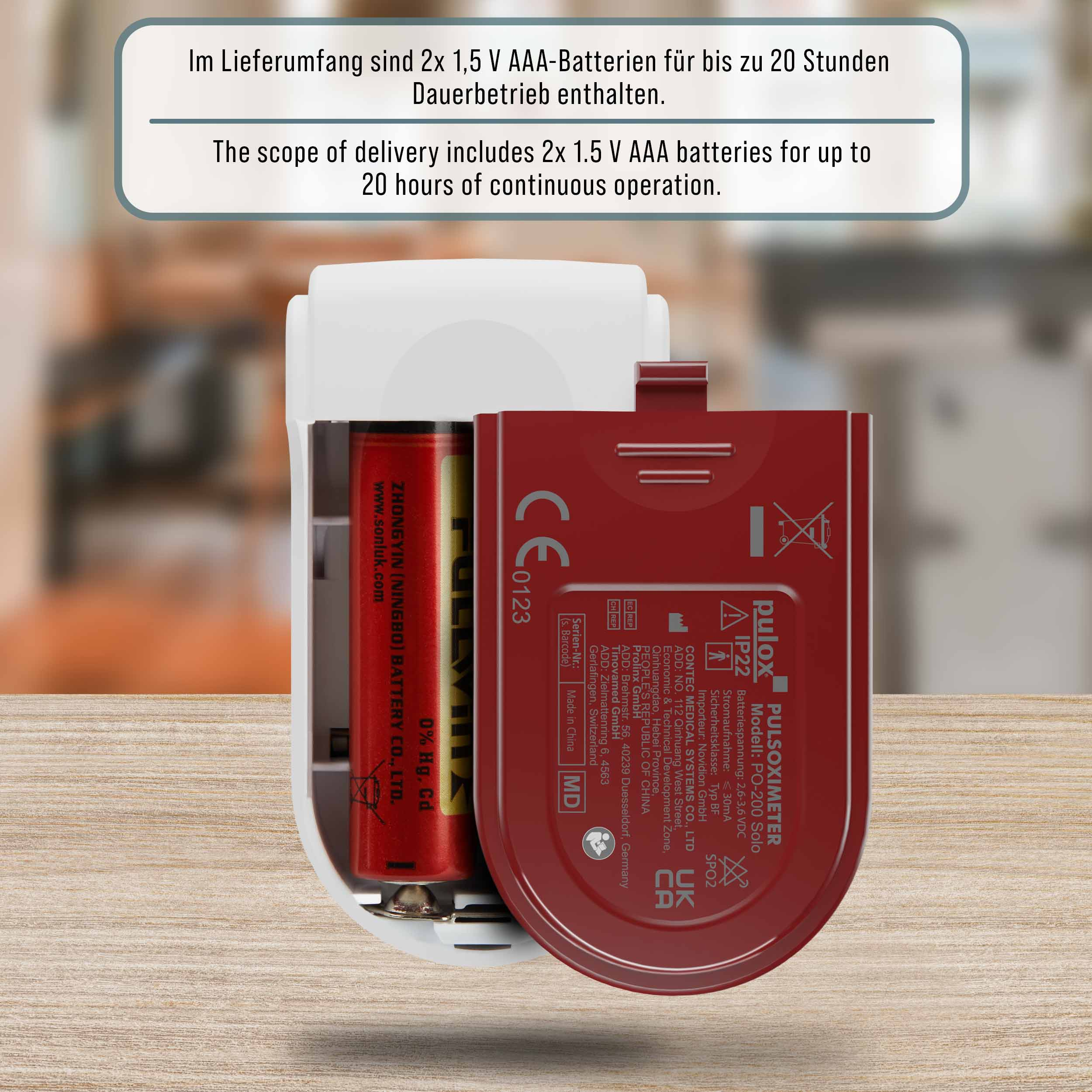 Ein roter Pulsoximeter mit einer AAA-Batterie, die in das Fach eingesetzt ist.